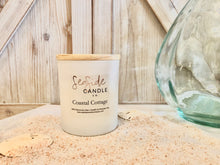 Load image into Gallery viewer, Escape to a tranquil beachside retreat with our Coastal Cottage candle. This elegant fragrance harmoniously blends refreshing bergamot and sea salt top notes with a heart of mint and peony, anchored by base notes of juniper, light musk, and marine accords, creating a soothing and atmospheric scent.
