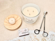 Load image into Gallery viewer, Coastal Cottage Candle: Your Seaside Sanctuary

Escape to a tranquil beachside retreat with our Coastal Cottage candle. This elegant fragrance harmoniously blends refreshing bergamot and sea salt top notes with a heart of mint and peony, anchored by base notes of juniper, light musk, and marine accords, creating a soothing and atmospheric scent.

Three sizes available:

One wick 10 oz. Glass | Double wick 13.5 oz. Glass | Three wick 16.5 oz. Glass

