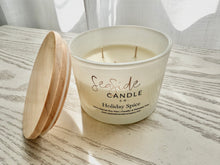Load image into Gallery viewer, Candle with wooden lid on a light wooden surface. 
