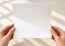 Load image into Gallery viewer, Open white greeting card held in hands, showing a blank interior for a handwritten message.