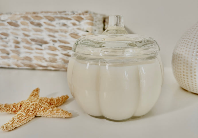 Pumpkin Souffle soy wax candle in clear pumpkin-shaped glass jar with two wicks and seashells