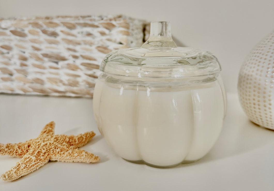 Pumpkin Souffle soy wax candle in clear pumpkin-shaped glass jar with two wicks and seashells
